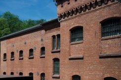 Ehemaliger Hafttrakt Rot geklinkter Bau mit Fenstern die mit Gittern vor den Fenstern.