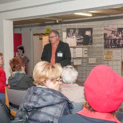 Bildungsfahrtteilnehmer sitzend in dem Ausstellungsraum des ehemaligen Hochbunkers