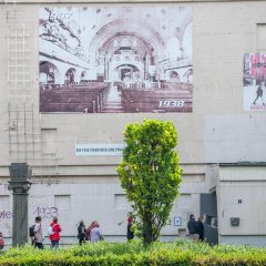 Betonwand mit großem Plakat  mit der  Innenansicht des ehemaligen Hochbunkers