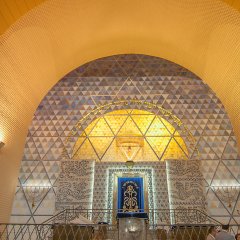 Goldenfarbener Altarbereich mit einem großen Bogen aus Mosaiksteinen