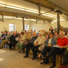 Bildungsfahrtteilnehmer im Ausstellungsraum der Gedenkstätte sitzend