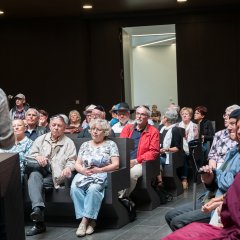 Bildungsfahrtteilnehmer in Bänken sitzend im Innenraum der neuen Synagoge