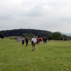 Bildtungsfahrtteilnehmer auf grüner Wiese in Richtung alten Kontrollturm laufend