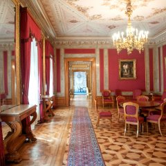 Läufer über Parkett und rote gepolsterte Stühle in einem historischen Raum des Schlosses