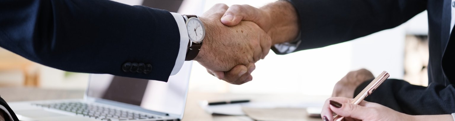 Zwei Geschäftsleute besiegeln einen Vertrag mit Handschlag