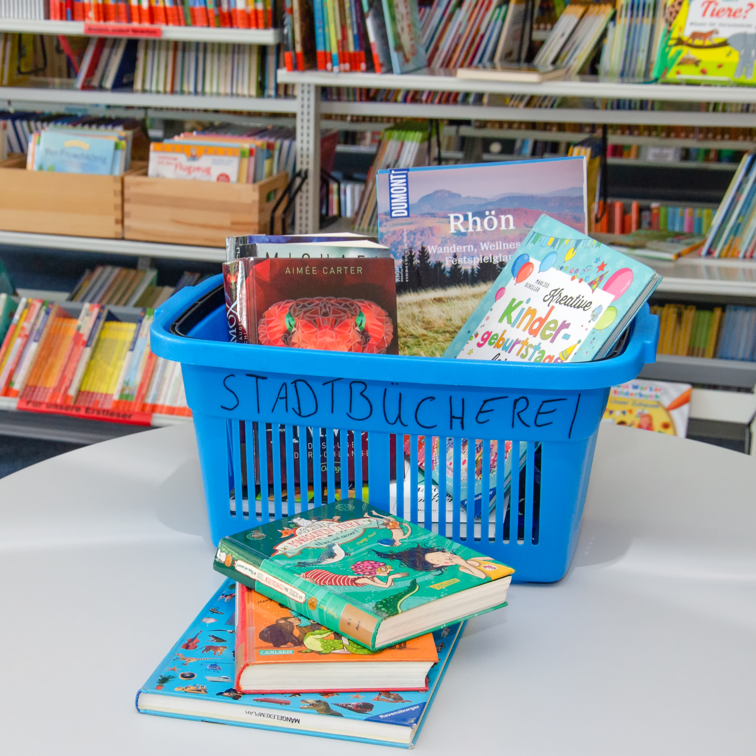 Blauer Büchereikorb gefüllt mit allerlei Kinderbücher