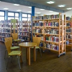 Sitzgruppe aus Holz vor den Bücherregalen der Bücherei Mörfelden