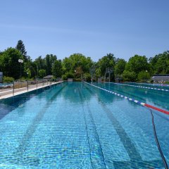 Großes Schwimmerbecken mit auf dem Wasser liegenden Bahnenabtrennungen.