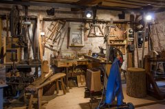 Blaue Jacke vor Holzsägen und weiteren Holzwerkzeugen.