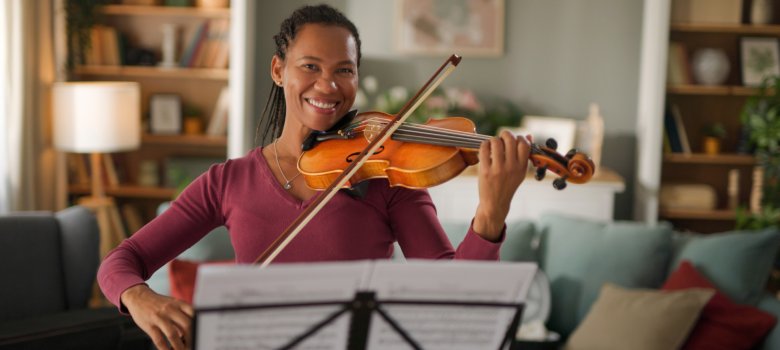 Mid adult woman playing violin at home Mid adult woman playing violin at home