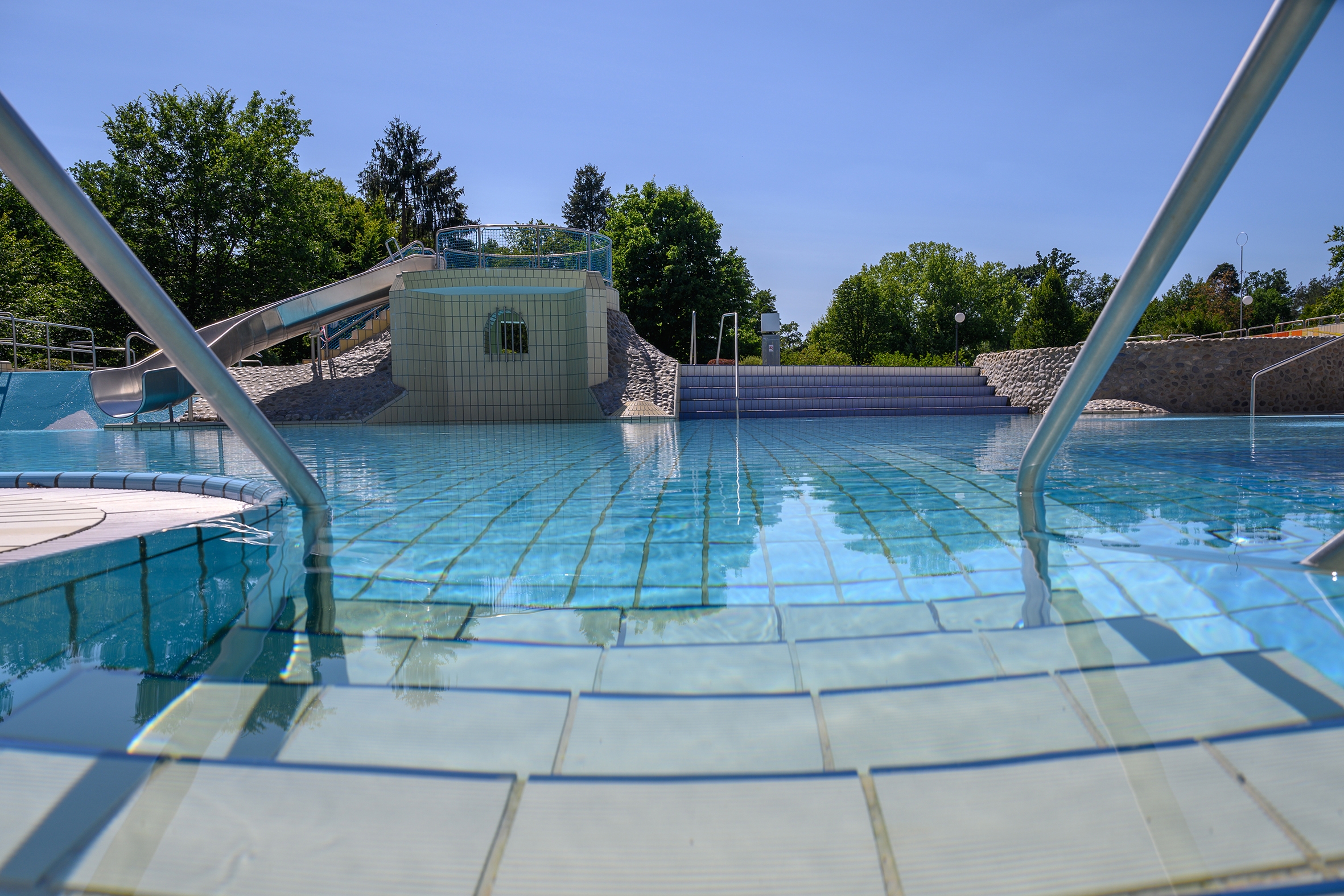 gefliester Treppenzugang mit Handlauf in das Nichtschwimmerbecken.