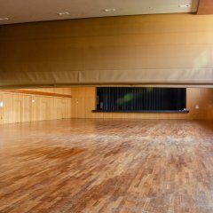 Großer Saal mit Parkettboden und bis zu Hälfte heruntergelassen Trennwand