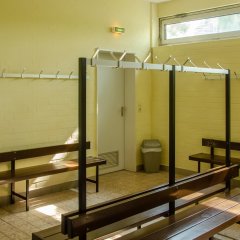 Holzsitzbänke mit Metall Aufhänger vor gelber Wand