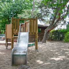 Holzpodest und Metallrutsche im Sandkasten.