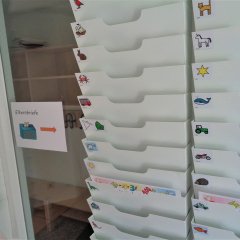 Weiße Plastikfächer mit bunten Aufklebern.