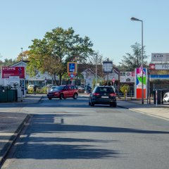 Opelstraße mit Supermarkt im Hintergrund und Getränkemarkt auf der rechten Seite
