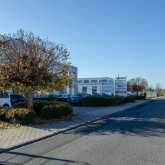 Bürogebäude mit parkenden Autos im Vordergrund