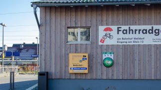 Defibrillator an der Holzverkleidung der Fahrradgarage