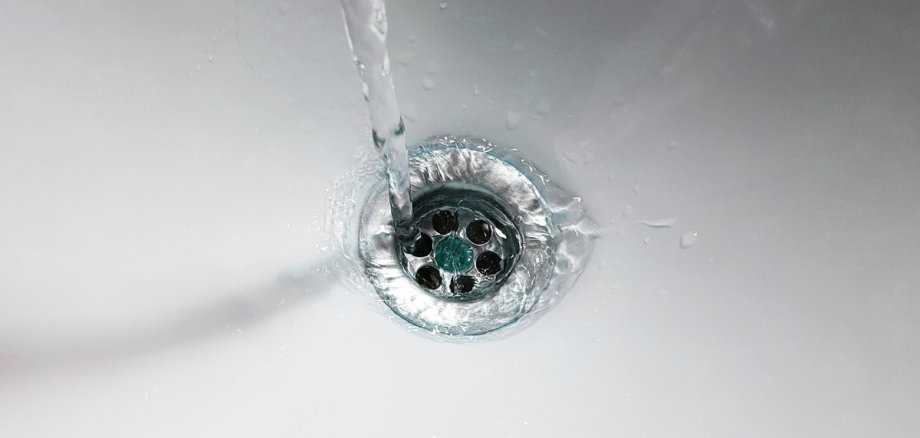 Wasser läuft in den Ausguss eines Waschbeckens