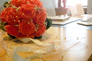 Ein Brautstrauß aus rosafarbenden Rosen mit Schleifen