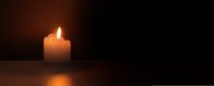 Eine kleine Kerze leuchtet in der Dunkelheit