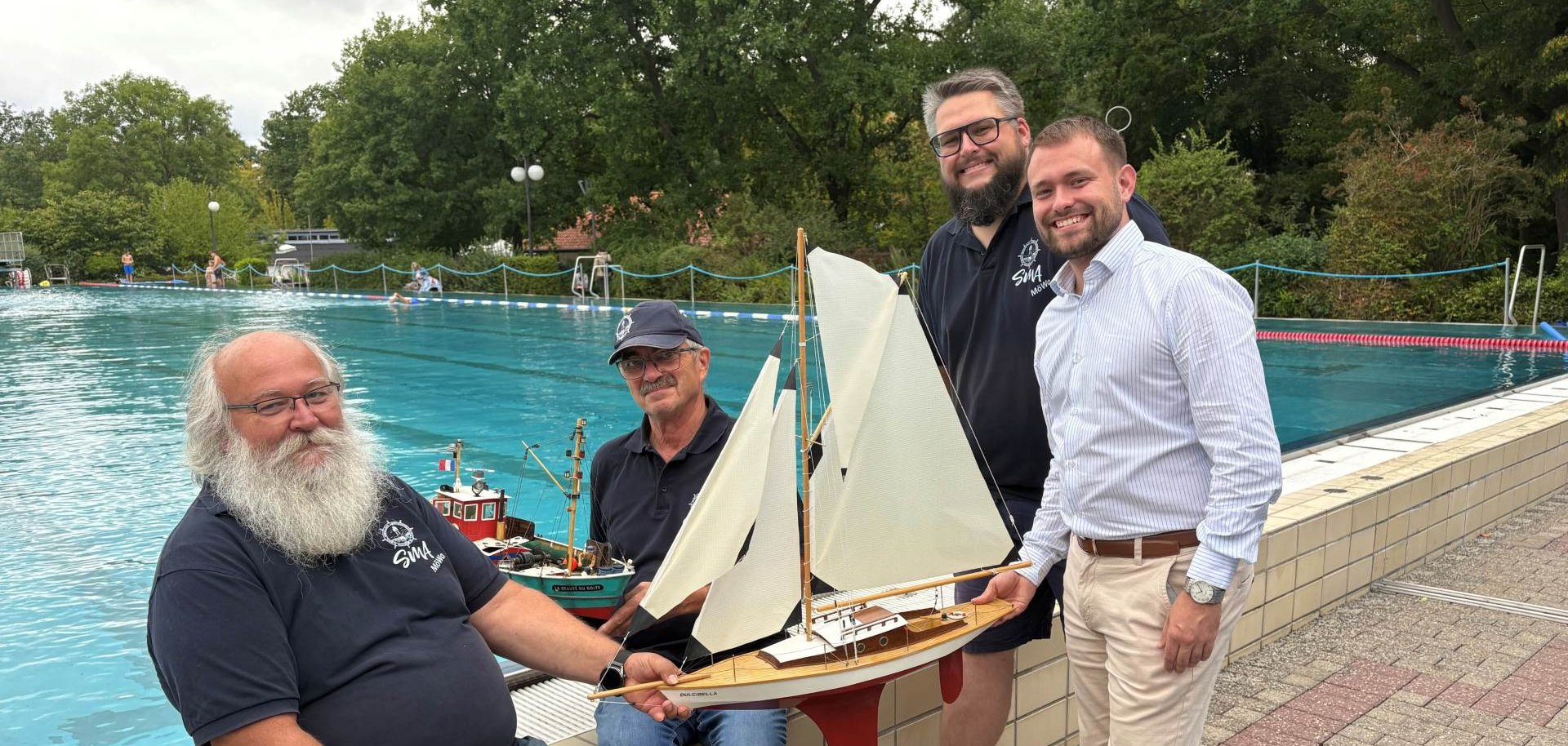 Die Modellbauer Manfred Schluckebier, Hermann Veith und Christoph Ritschel planten mit Stadtrat Maximilian Gegenheimer (von links) den Saisonabschluss im Waldschwimmbad (Foto vor dem Schwimmerbecken im Waldschwimmbad).