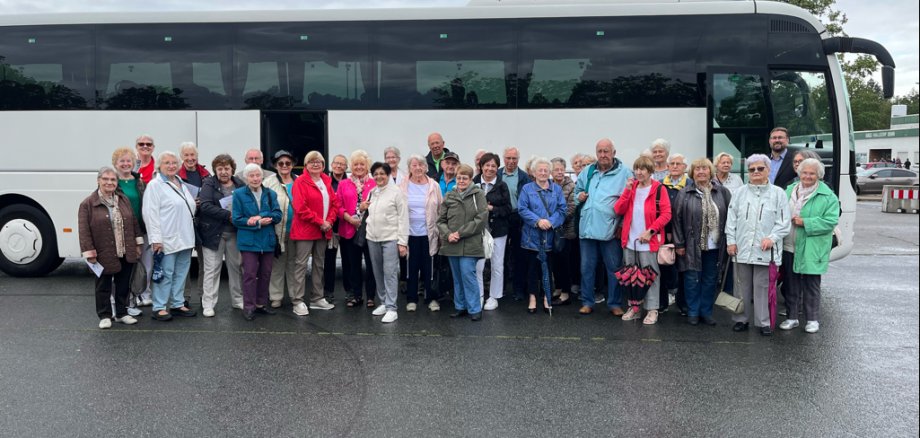 Gruppe älterer Menschen und Erster Stadtrat Karsten Groß vor einem Bus