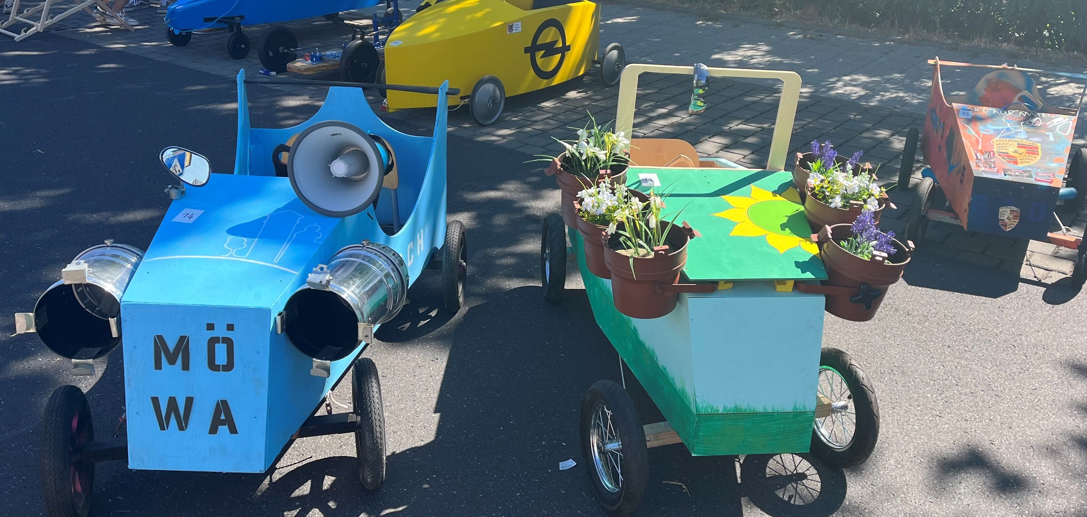 Zwei Seifenisten. Die linke ist blau angemalt. Vorne steht MöWa. Die rechte ist grün mit bemalten Sonnenlumen und einem Blumetopf an der Seite